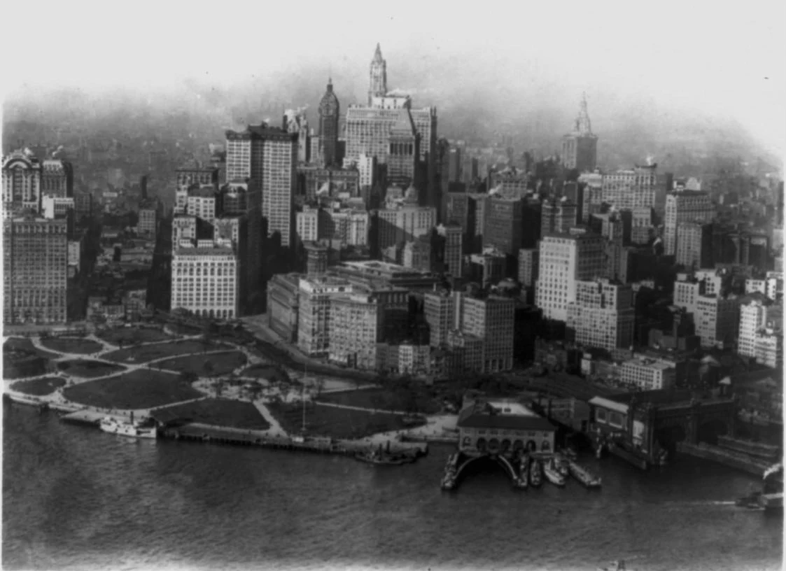 A black and white 1923 aerial photo of Battery Park at the southern tip of Manhattan, with downtown towers rising behind it