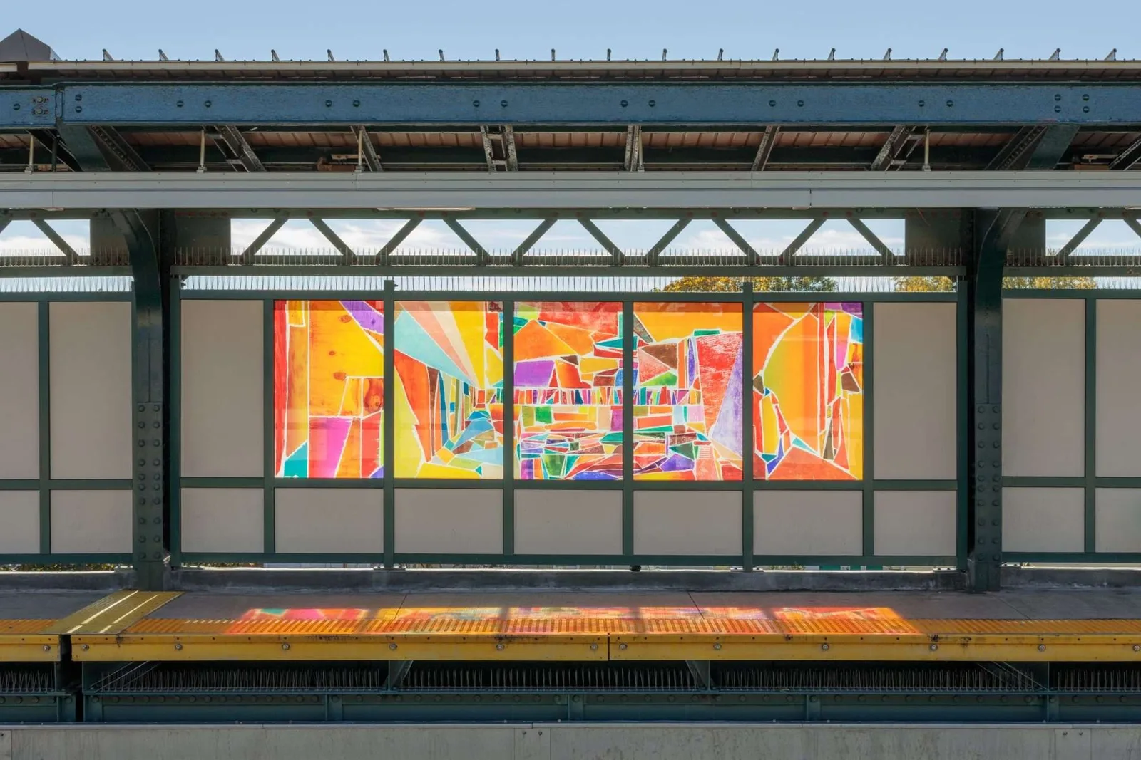 Laminated glass panels on an elevated subway platform, printed with images of wood grain and fragments