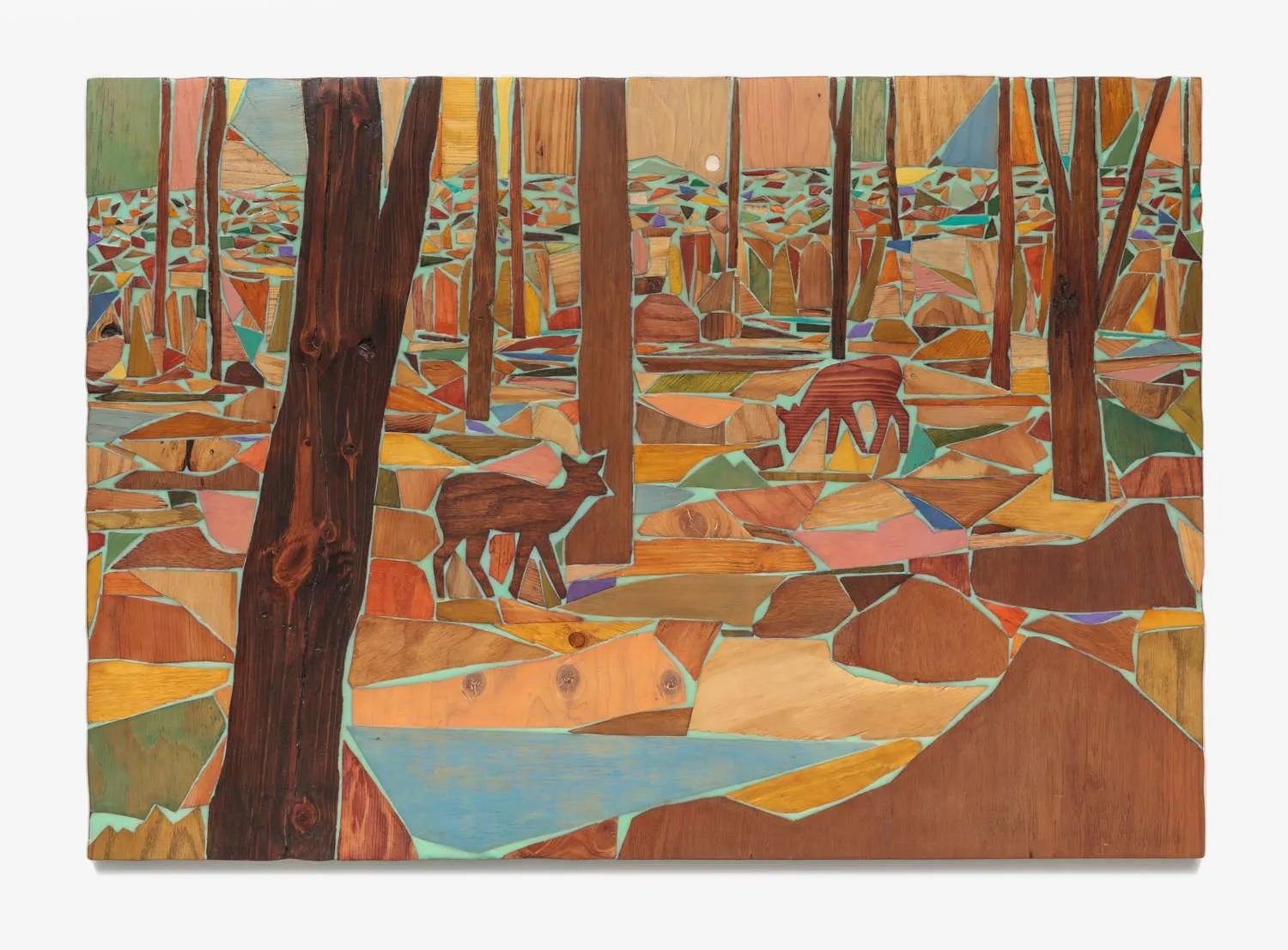 A wood relief of two deer standing among layered trees