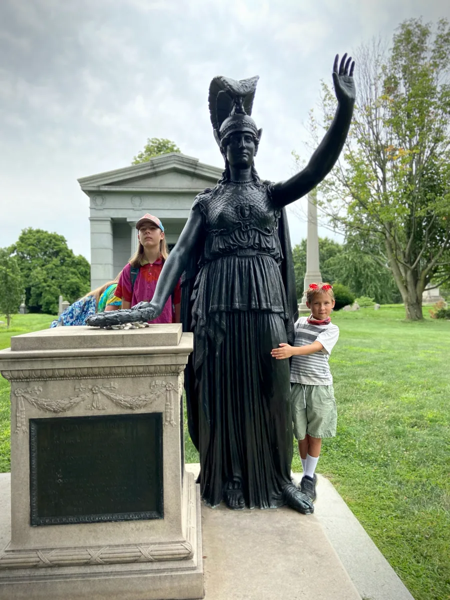 Jason’s children beside the bronze statue of Minerva on Battle Hill, her arm raised toward the harbor